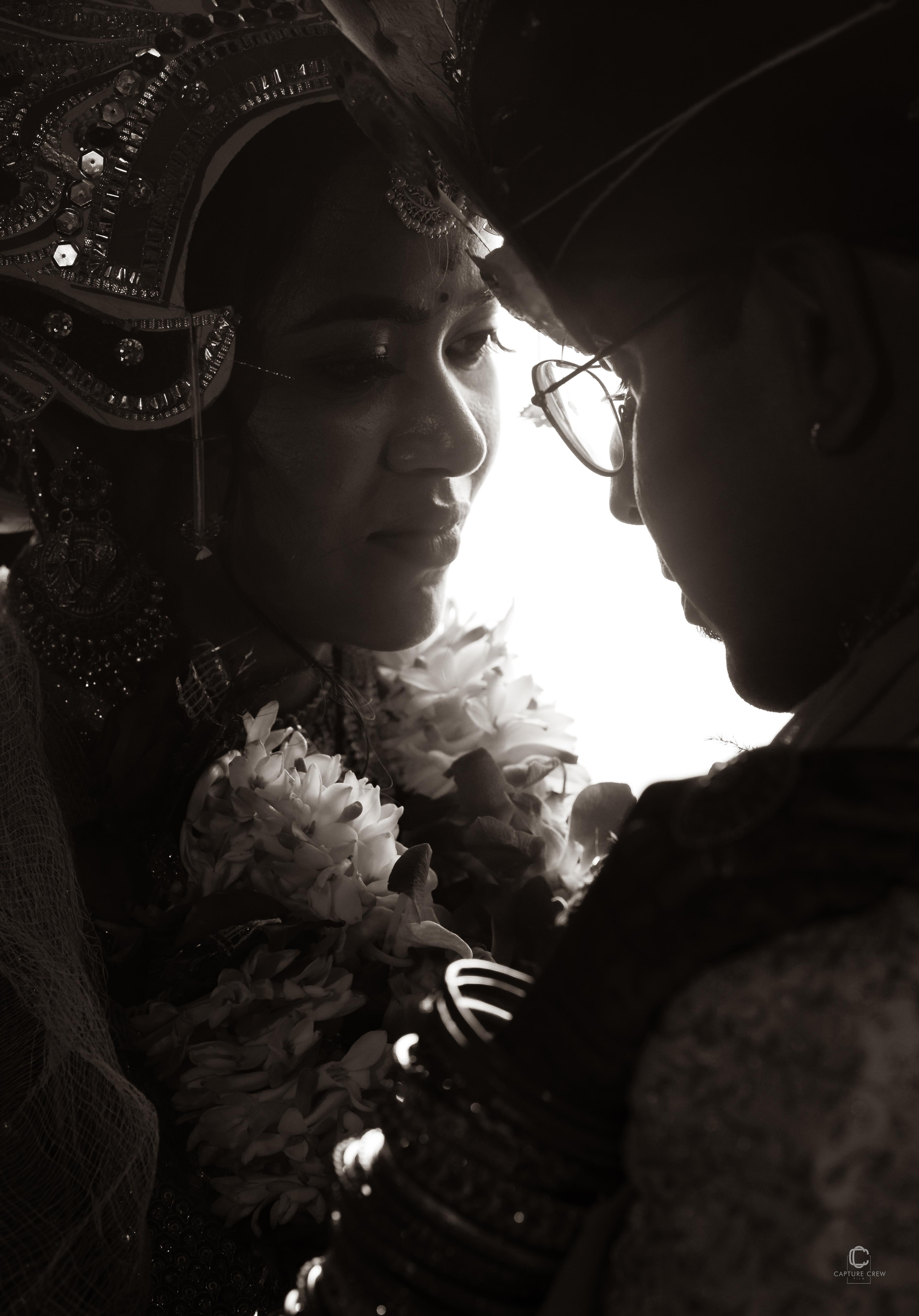 Dramatic black and white wedding portrait with backlight - intimate moment between Indian bride and groom with traditional wedding garlands - moody wedding photography by CaptureCrew Films | TCCF Photography Bhubaneswar